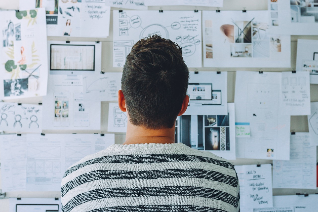 Man looking at a whiteboard containing lots of notes